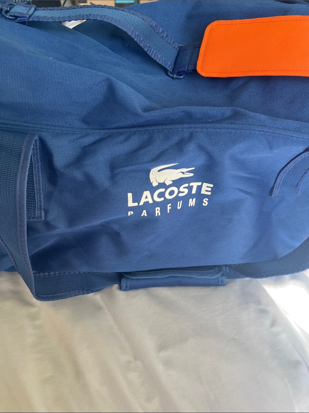 Lacoste Navy Duffel Bag with Orange Strap Accent